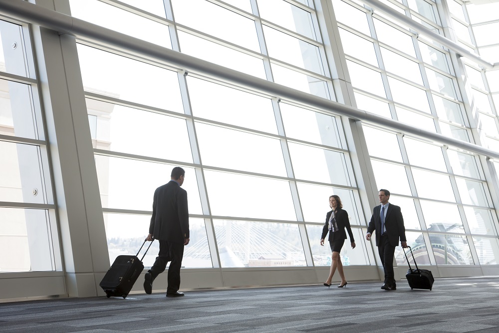 USA,Three business people walking next to a large window in a conference centre lobby. Was ist die Beschaffung von Geschäftsreisen?