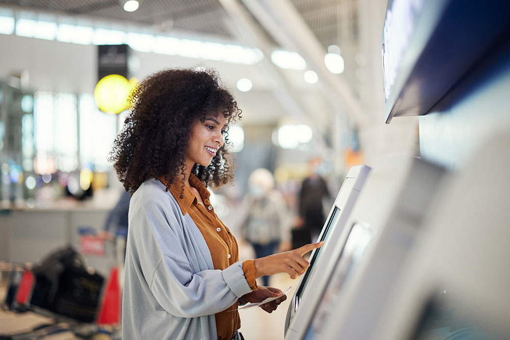 black-woman-airport-and-smile-by-self-service-sta-2023-03-08-18-44-50-utc_1000x667