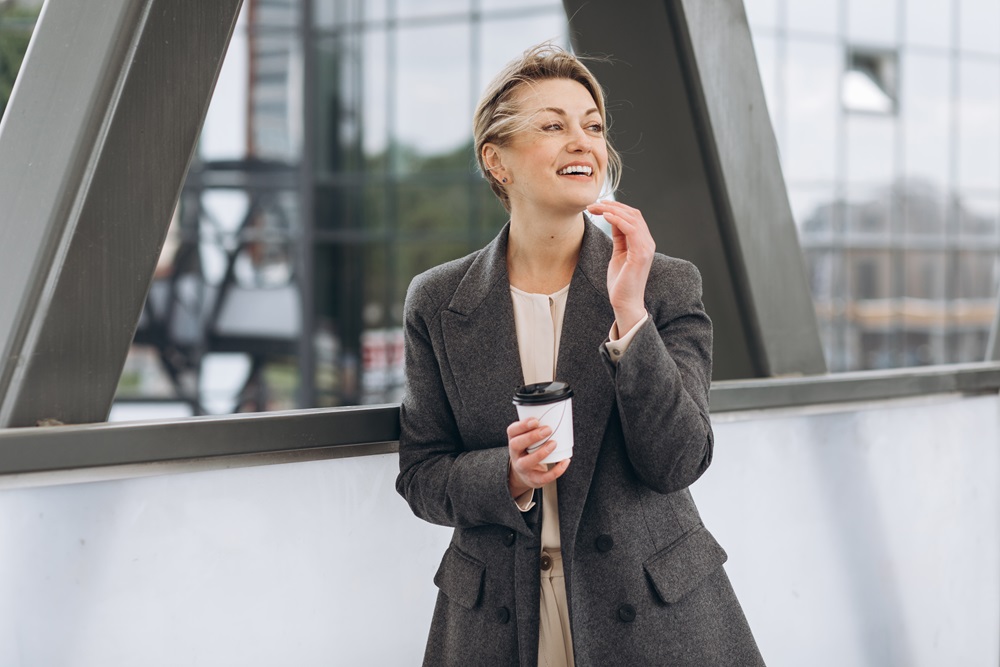 Portrait of a mature business woman smiling with emotions and dr Business woman with coffee on business trip
