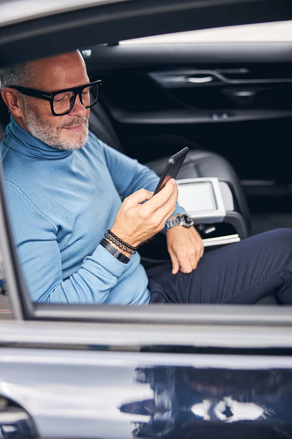 Businessman using his smartphone in the car business traveler on the phone