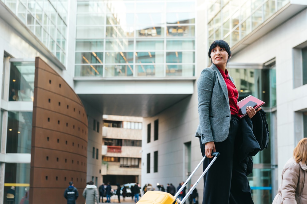 Business traveler with suidcase outside office building