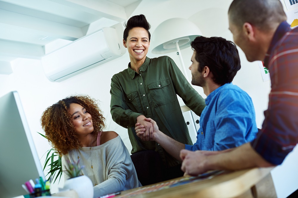 Shot of two businesspeople shaking hands while having an informal meeting. geschäftsetikette