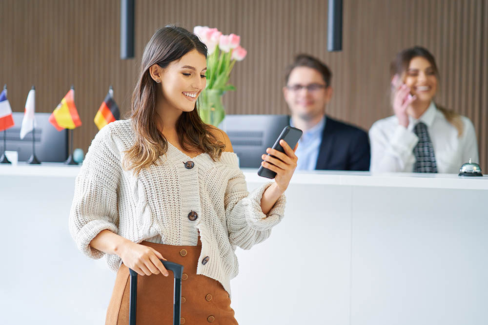 Female tourist waiting at reception desk in hotel Reisende beim Einchecken im Hotel