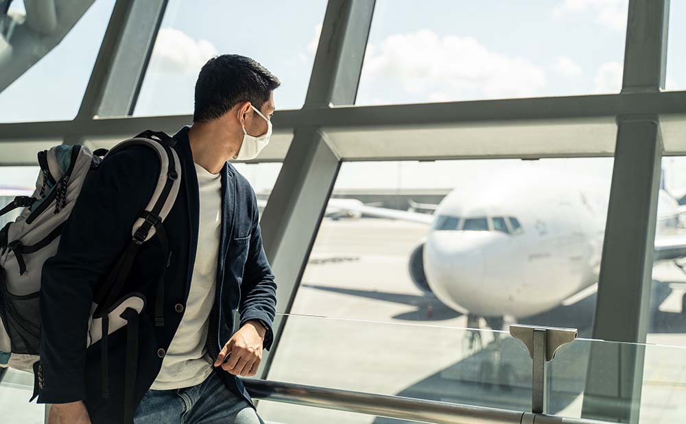 Asian traveler business man wearing face mask waiting to board i get going travel