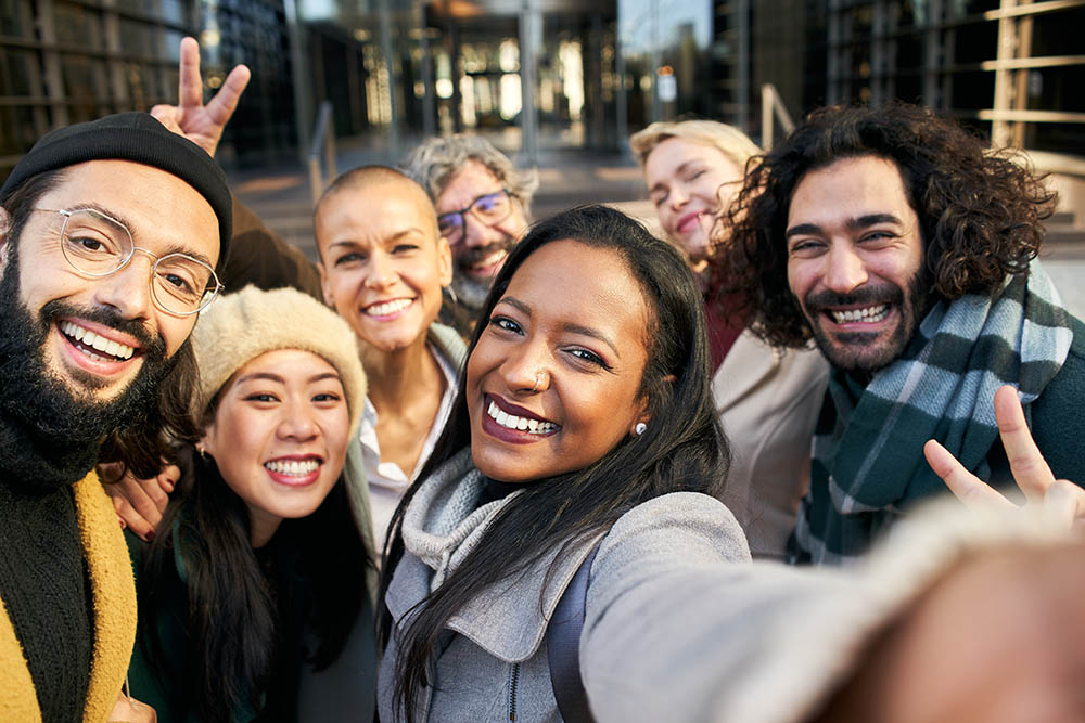 Selfie of a group of happy business people taking photo with a phone happy employees, company perks