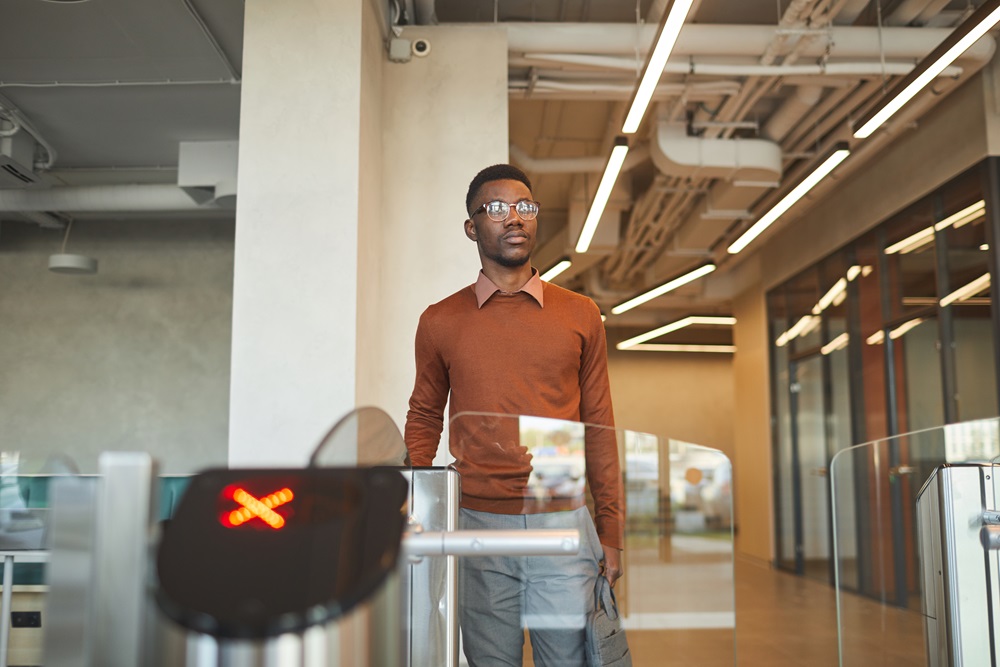 African-American Man Passing Turnstile Mann mit TSA-Vorkontrolle beim Durchlaufen der Sicherheitskontrolle