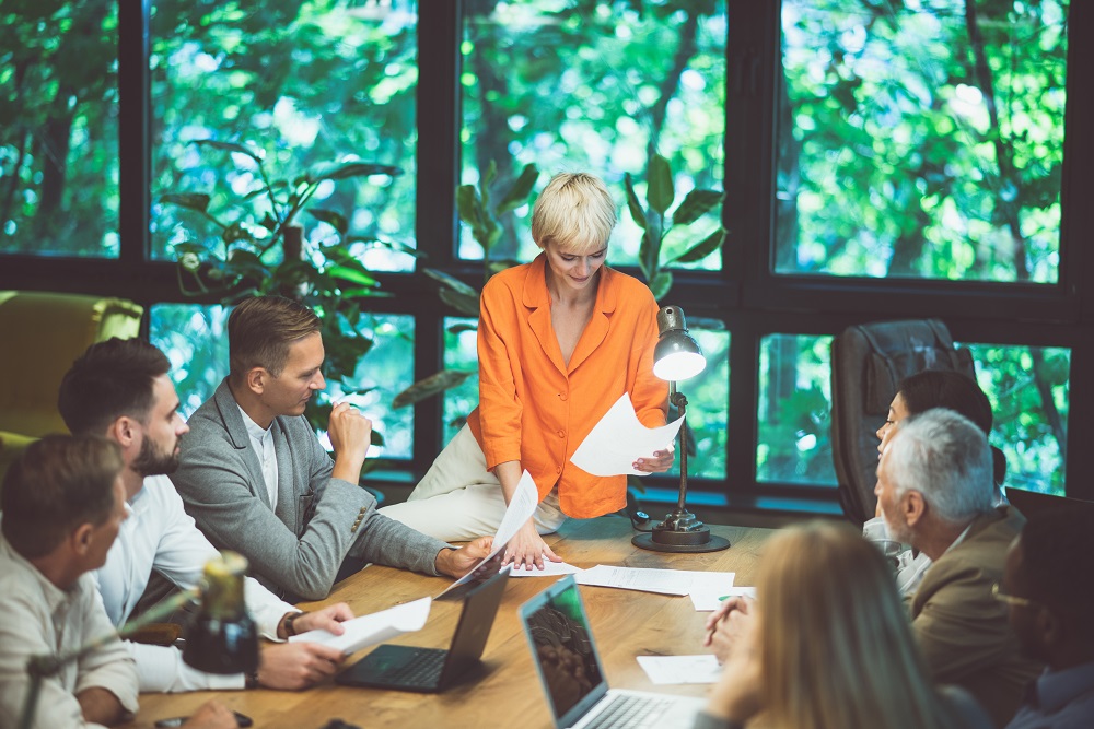 cinematic image of people working in a start up business. Kollegen in einem Besprechungsraum, der von Bäumen umgeben ist