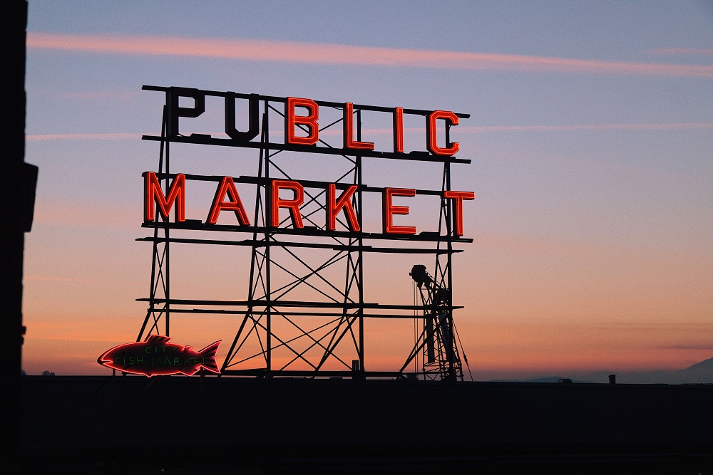 Neon public market sign at Pike Place Market and Elliott bay during the sunset pike place markt