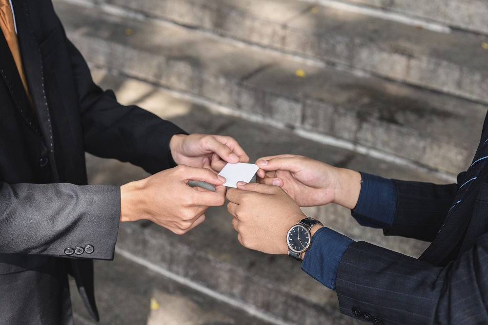 Visitenkartenaustausch in APAC Visitenkartenaustausch mit zwei Händen in Asien